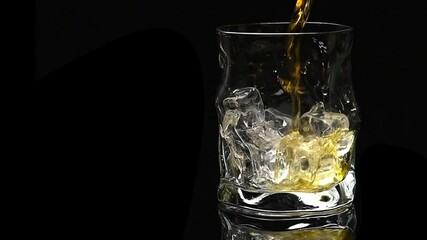 whiskey is poured into a crystal glass with ice on a black background