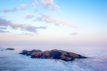 Colorful sunrise on the green hills of Appenzell in Switerland as they emerge from the clouds and fog in an autumn morning