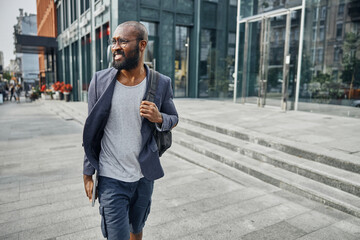 Positive delighted male person leaving business center