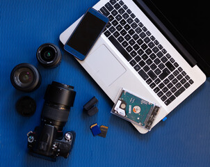 Zenithal view of photographic and related products, a camera, lenses, laptop...