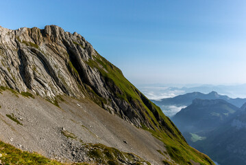 Fototapeta na wymiar The Alpstein mountain range in Appenzell, Switzerland with the fog in the valley and the view of the Seealpsee lake