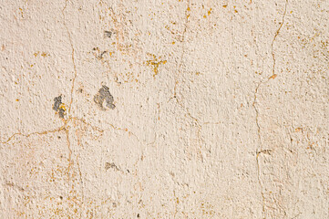 Grunge background of cracked cloud peeled putty wall in beige tones