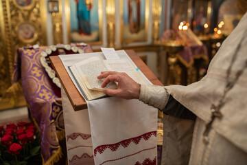 Hands of christian orthodox priest reading a bible.