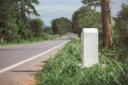 Empty white kilometer marker beside the road in Thailand.