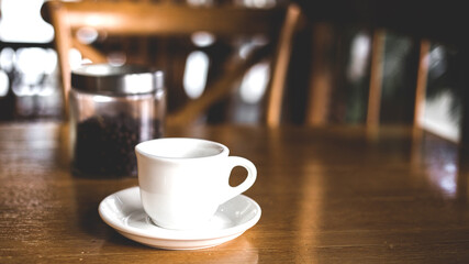 A white coffee cup on a brown wooden table.