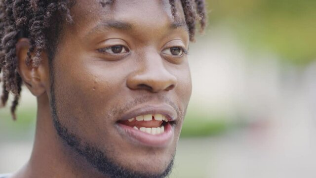 Expressive young black man giving answers whilst being interviewed in the street