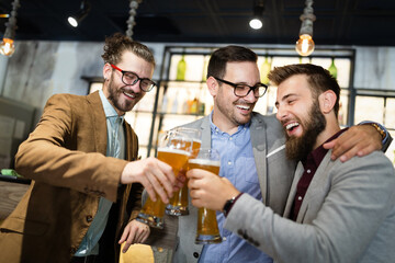 Business people drink beer after work in pub. Businessmen enjoy a beer.