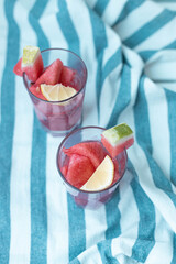 Glass glasses with watermelon pulp cocktail on striped towel