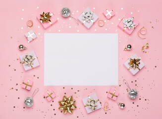 Gold and silver decorations, mirror disco balls, gifts on pastel pink paper background.