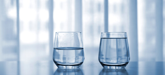 Zwei Gläser Wasser, halbvoll und voll