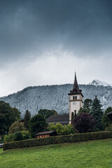 Fototapeta na wymiar church of Grindelwald in autumn with first snow on the mountains