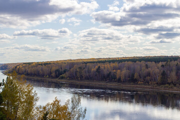 Beautiful, wide river autumn among the woods.