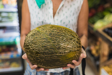 white woman holding a melon in her arms