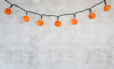 Halloween background with plastic small orange pumpkin light and small wood black house on white...