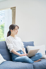 Fototapeta premium ソファーでパソコンを使う女性