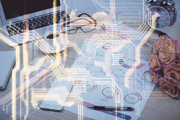 Computer on desktop in office with technology theme hologram. Double exposure. Tech concept.