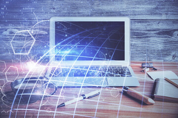 Double exposure of desktop with computer and world map hologram. International data network concept.