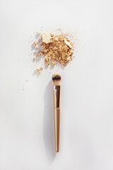 Makeup brush with powder foundation isolated on white.
