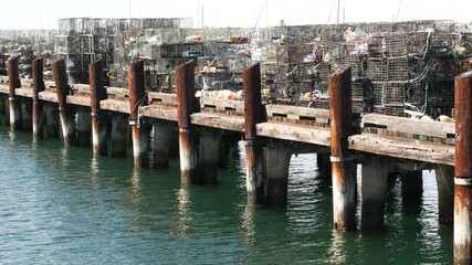 Traps, ropes and cages on pier, commercial dock, fishing industry in San Diego harbor, California USA. Empty pots and creels for seafood catching in port. Many fishermen's nets and baskets in seaport