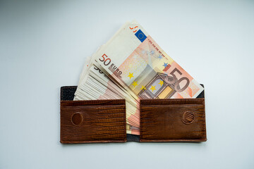 euro banknotes in fat brown wallet