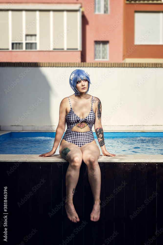 Sticker vertical shot of a european female with a blue cosplay wig at swimming pool