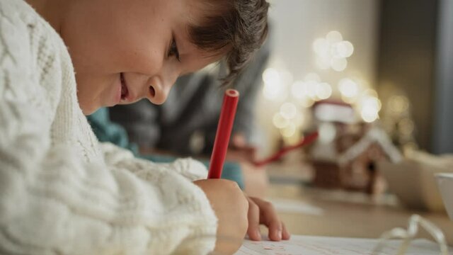 Handheld video of little boy focused on writing letter to Santa Claus. Shot with RED helium camera in 8K.