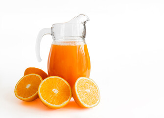 Cut fresh orange juice in a jug and a few oranges in half. Isolated on white. Copy space