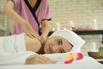 Obraz na płótnie Canvas therapist's hand is massaging a woman's shoulder in spa salon.