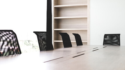 Simple modern office interior with wooden table and black chairs. © bancha