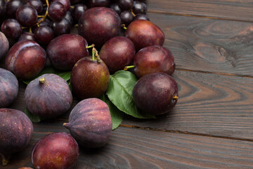Still life of fruits. Bunch of grapes. Figs and plums on table.