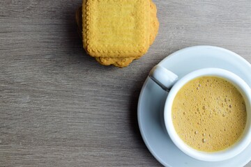 Close up. Cup with coffee with milk, accompanied by some baked cookies