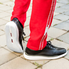 Man leather black sport sneakers close up
