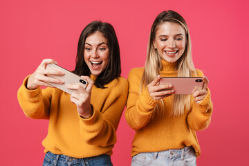 Image of delighted nice women playing video game on smartphones