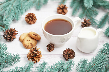 Obraz na płótnie Canvas Christmas table setting. Cup of coffee or tea on background of Christmas tree. Christmastime celebration. Winter Holidays. Xmas mock up. Greeting card template.