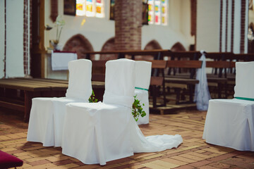 Church sanctuary before a wedding ceremony. Empty chairs for bride and groom.
