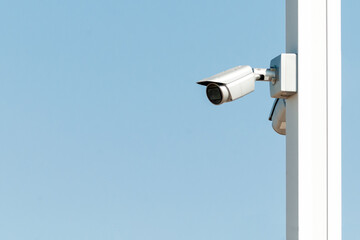 Security camera on the blue wall in summer day