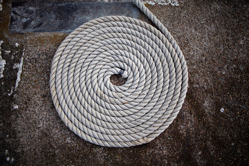 Fototapeta na wymiar Rope arranged in a perfect circle on a concrete pier