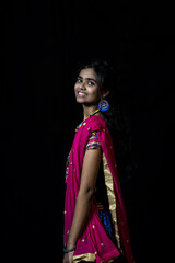 Indian girl in traditional chaniya choli for navratri with a fashionable hairstyle poses in studio...
