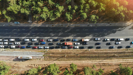 Aerial. Traffic jam with a lot of cars on a highway between forest. Peak hour. Top view from drone.