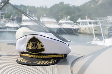 White sea captain's cap on the dashboard of the boat