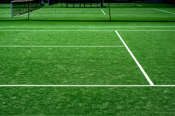 Fototapeta premium White lined green grass tennis court