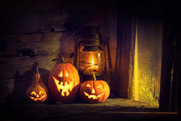 Halloween pumpkins and lantern in an old house by the window where the moonlight shines