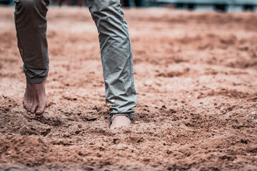 Horse whisperer walking barefoot on the sandpit. Moments before the show begins, natural feeling...
