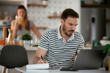 Young man working on project. Handsome man working at home..