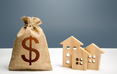 Dollar money bag and figurines of residential buildings. Mortgage loan. City municipal budget....