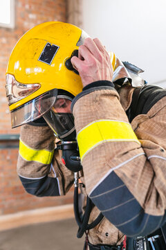 Unrecognizable firefighter with a yellow helmet