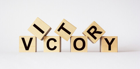 Victory, text on wooden cubes on light background