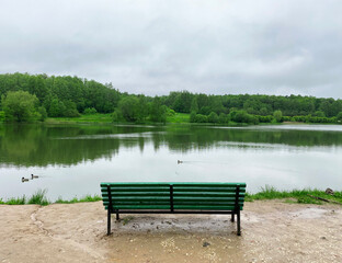 Bench on the Bank of the Lebedyansky pond, where ducks swim, in Izmailovsky Park, Moscow