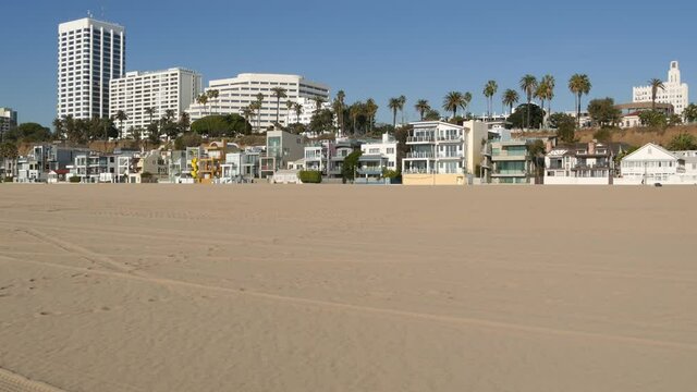 California summertime beach aesthetic, sunny blue sky, sand and many different beachfront weekend houses. Seafront buildings, real estate in Santa Monica pacific ocean resort near Los Angeles CA USA.