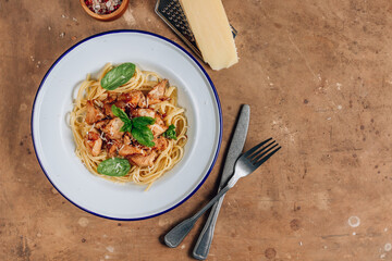 Spaghetti with chicken and basil in an enamel plate